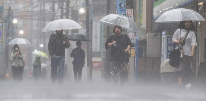 En Kawasaki, prefectura de Kanagawa, Japón, la gente se desplaza bajo la intensa lluvia provocada por la fuerte tormenta tropical Jangmi.