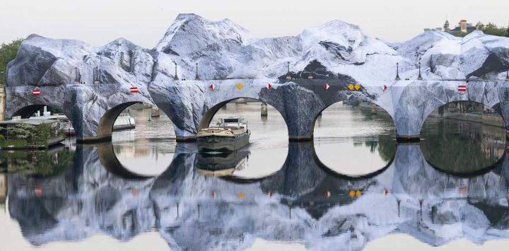 Esta fotografía, tomada en el puente Pont-Neuf de París, muestra la instalación de "La cueva del Pont Neuf", la obra más reciente del fotógrafo y artista callejero francés JR. Como homenaje a la performance "Pont Neuf wrapped" de los artistas franceses Christo y Jeanne-Claude en 1985 sobre el puente más antiguo de París, JR transformará por completo el Pont Neuf en una larga y monumental "caverna" de lienzos y espacio abierto que cambiará el horizonte de la capital.
