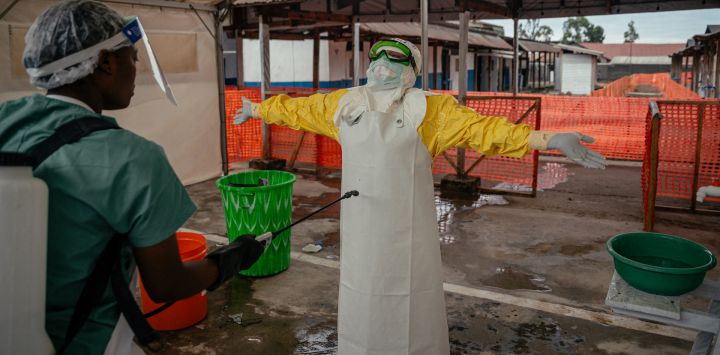 Tras completar sus rondas en la zona roja aislada para monitorear a los pacientes, brindar atención y garantizar la higiene, un médico de Médicos Sin Fronteras (MSF) se quita el equipo de protección personal (EPP) durante la descontaminación en el área de desvestirse y desinfección del Centro de Tratamiento del Ébola (CTE) en Munigi. El único aeropuerto que permite a las organizaciones humanitarias acceder al epicentro del brote de ébola en la República Democrática del Congo reabrió sus puertas cuando disminuyó el número de casos sospechosos reportados.