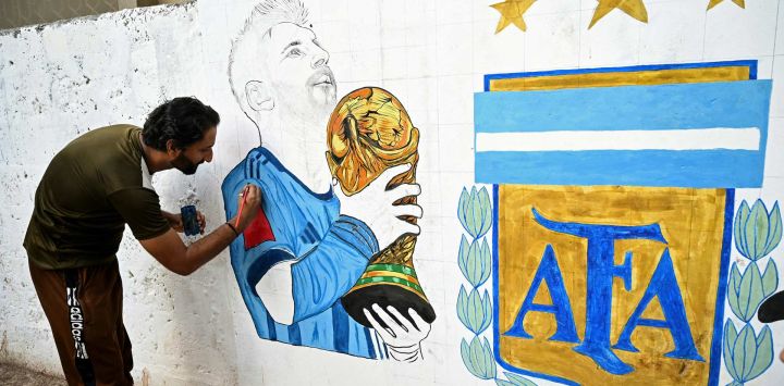 Un aficionado al fútbol pinta un mural en una calle de Karachi, Pakistán, con motivo de la Copa Mundial de la FIFA 2026.