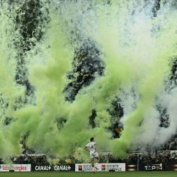 El ala francés del Montauban, Jean Seux, participa en el calentamiento mientras se eleva humo verde antes del partido de rugby Top 14 francés entre la Section Paloise Bearn Pyrenees (Pau) y el US Montauban en el Stade du Hameau en Pau, al suroeste de Francia. | Foto:Philippe Lopez / AFP