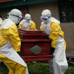 Miembros de un equipo de la Cruz Roja Congoleña, con equipo de protección personal, transportan el ataúd de una mujer presuntamente fallecida por la enfermedad del virus del Ébola, antes de su entierro seguro en su casa en Bunia. La UE anunció el envío de 100 toneladas de ayuda humanitaria a una zona de difícil acceso en el este de la República Democrática del Congo, afectada por un brote de Ébola. | Foto:Jospin Mwisha / AFP