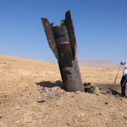 Un hombre posa para una foto junto a un cohete caído, medio enterrado en el suelo, en las afueras de Jericó, tras los ataques de Irán y de los rebeldes hutíes, respaldados por Irán. Israel e Irán intercambiaron disparos poniendo a prueba seriamente una frágil tregua y amenazando las esperanzas de un acuerdo para poner fin a la guerra en Oriente Medio. | Foto:AHMAD GHARABLI / AFP