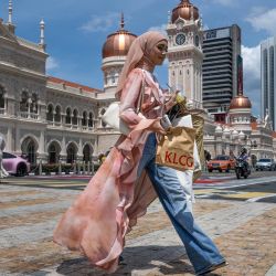 Una mujer cruza la calle frente al edificio Sultan Abdul Samad, cerca de la plaza Merdeka en Kuala Lumpur, Malasia. | Foto:Mohd Rasfan / AFP