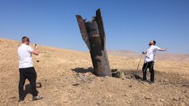 Un hombre posa para una foto junto a un cohete caído, medio enterrado en el suelo, en las afueras de Jericó, tras los ataques de Irán y de los rebeldes hutíes, respaldados por Irán. Israel e Irán intercambiaron disparos poniendo a prueba seriamente una frágil tregua y amenazando las esperanzas de un acuerdo para poner fin a la guerra en Oriente Medio.