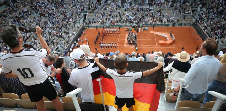 Aficionados alemanes celebran en las tribunas mientras Alexander Zverev, de Alemania, levanta el trofeo tras ganar la final individual masculina del Abierto de Francia contra el italiano Flavio Cobolli en la pista Philippe-Chatrier, en la jornada 15 del torneo de tenis Roland-Garros en París.
