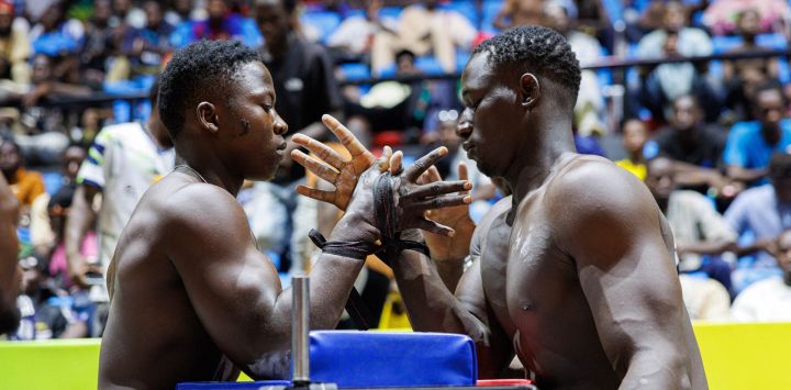 Atletas compiten en una lucha de brazos durante una competición en el Palacio de Deportes Salamatou Maiga en Bamako, Malí.