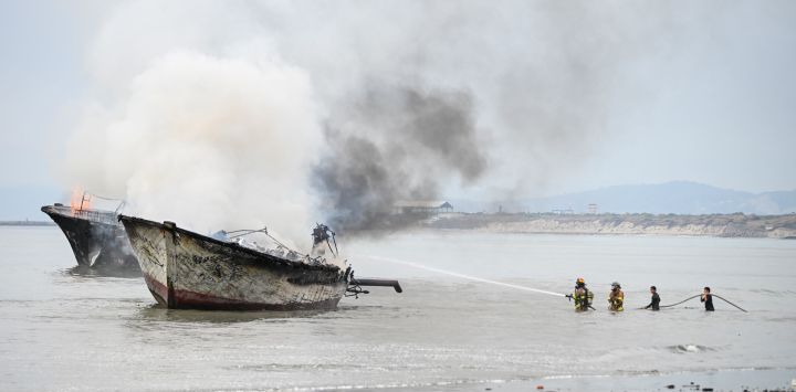 Bomberos trabajan para extinguir el incendio en una embarcación en el puerto de Manta, en la provincia de Manabí, Ecuador. Dos personas resultaron heridas y al menos 35 embarcaciones fueron destruidas por un incendio en el área de pesca artesanal de la Autoridad Portuaria de Manta, ubicada dentro del puerto ecuatoriano de Manta, en la provincia occidental de Manabí, informó la Secretaría Nacional de Gestión de Riesgos.