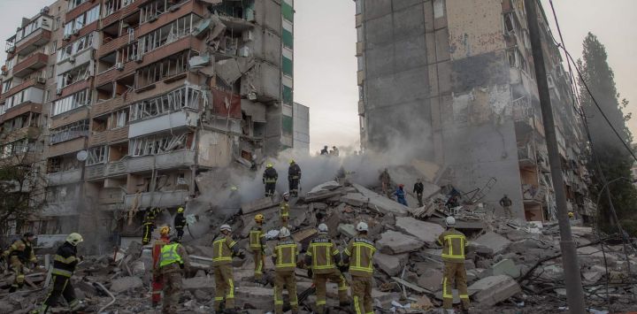 Los equipos de rescate trabajan en un edificio residencial parcialmente destruido tras los ataques con drones y misiles rusos en Kiev, en el contexto de la invasión rusa de Ucrania.