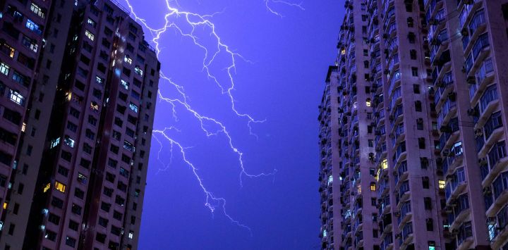 Los relámpagos iluminan el cielo sobre una zona residencial en el distrito de Tsuen Wan, en los Nuevos Territorios de Hong Kong.