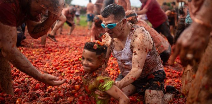 Un hombre agarra a un niño durante el XVI Festival de la Lucha del Tomate, conocido como "Tomatina", en Sutamarchan, departamento de Boyacá, Colombia.