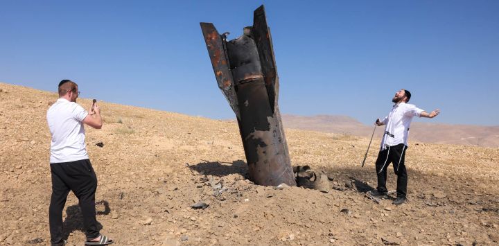 Un hombre posa para una foto junto a un cohete caído, medio enterrado en el suelo, en las afueras de Jericó, tras los ataques de Irán y de los rebeldes hutíes, respaldados por Irán. Israel e Irán intercambiaron disparos poniendo a prueba seriamente una frágil tregua y amenazando las esperanzas de un acuerdo para poner fin a la guerra en Oriente Medio.