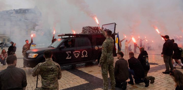 Los dolientes portan bengalas de humo durante la ceremonia fúnebre de Yaroslav Varnak, un militar de 23 años que murió en combate en Kiev, en medio de la invasión rusa de Ucrania.