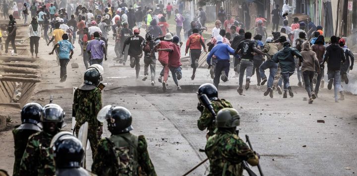 Manifestantes buscan refugio durante enfrentamientos con agentes de la policía keniana en una protesta contra un controvertido centro de cuarentena para el ébola, construido por Estados Unidos en la base aérea de Laikipia, en Nanyuki. Varios kenianos fueron arrestados en las últimas protestas contra la construcción de un centro de cuarentena para ciudadanos estadounidenses en una ciudad turística.