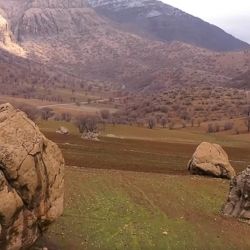 Una carretera de montaña serpenteante conduce hacia el asentamiento a través de un terreno árido, 
