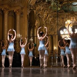 Alumnas de la sexta división de la Escuela de Danza de la Ópera de París calientan antes de una función en el Foyer de la Danse de la Ópera Garnier de París. Es una tradición transmitida oralmente de generación en generación: en la Escuela de Ballet de la Ópera de París, los alumnos aprenden el arte del ballet clásico francés, un legado artístico con tres siglos de historia que atrae cada vez a más bailarines extranjeros. | Foto:JOEL SAGET / AFP