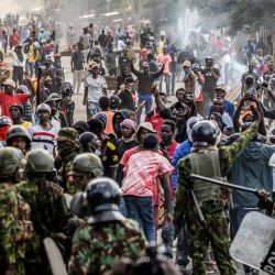Manifestantes se congregan y se enfrentan a agentes de la policía keniana durante una protesta contra un controvertido centro de cuarentena para el ébola, construido por Estados Unidos en la base aérea de Laikipia, en Nanyuki. Varios kenianos fueron arrestados ese mismo día en las últimas protestas contra la construcción de un centro de cuarentena para ciudadanos estadounidenses en una ciudad turística. El centro, ubicado en la base aérea de Laikipia, en Nanyuki, a la sombra del monte Kenia, albergará a los estadounidenses procedentes de la República Democrática del Congo (RDC), país que sufre un importante brote de ébola. | Foto:LUIS TATO / AFP