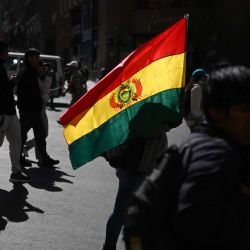 Personas con banderas bolivianas participan en una marcha contra los bloqueos y para exigir la renuncia del presidente de Bolivia, Rodrigo Paz, en La Paz. La Asamblea Nacional de Bolivia autorizó al presidente Rodrigo Paz a utilizar al ejército para despejar los bloqueos viales que han paralizado ciudades clave durante semanas. | Foto:MARVIN RECINOS / AFP