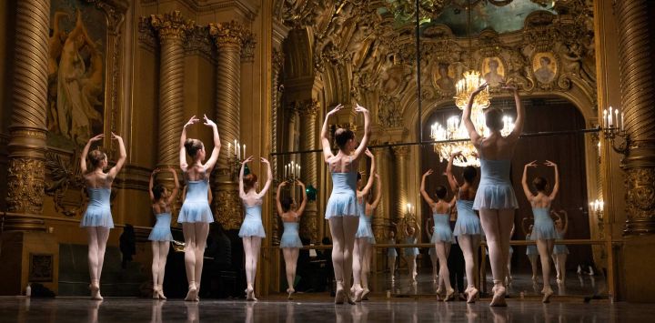 Alumnas de la sexta división de la Escuela de Danza de la Ópera de París calientan antes de una función en el Foyer de la Danse de la Ópera Garnier de París. Es una tradición transmitida oralmente de generación en generación: en la Escuela de Ballet de la Ópera de París, los alumnos aprenden el arte del ballet clásico francés, un legado artístico con tres siglos de historia que atrae cada vez a más bailarines extranjeros.