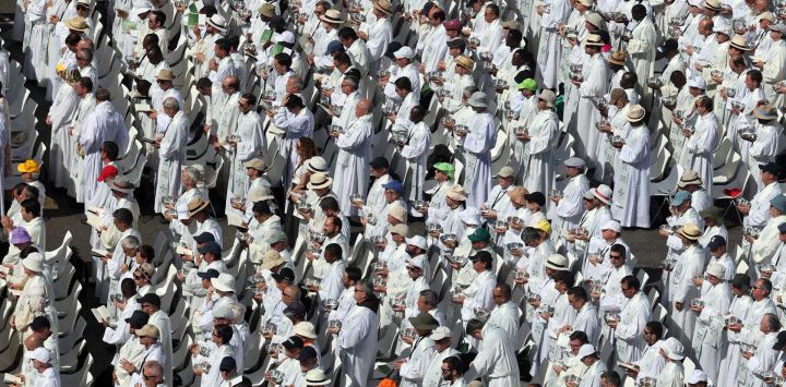 Los sacerdotes sostienen copones con las hostias sagradas antes de administrar la Comunión a los fieles en las calles aledañas a la Plaza de Cibeles, durante la Santa Misa oficiada por el Papa León XIV en Madrid.