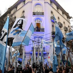 La expresidenta argentina (2007-2015), Cristina Kirchner, aparece en el balcón de su casa mientras permanece bajo arresto domiciliario en Buenos Aires. Kirchner cumple un año desde que fue condenada a seis años de prisión y se le prohibió ejercer cargos públicos de por vida. | Foto:LUIS ROBAYO / AFP