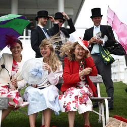 Los asistentes a las carreras luchan contra el viento antes del inicio del segundo día del Festival de Carreras de Caballos de Epsom, en Surrey, al sur de Inglaterra. | Foto:HENRY NICHOLLS / AFP