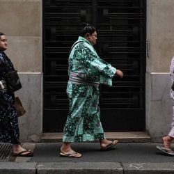 Luchadores de sumo caminan por una calle de París. París acoge el Torneo de Sumo de junio de 2026. | Foto:Simon Wohlfahrt / AFP