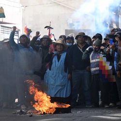 Manifestantes corean consignas cerca de un objeto en llamas durante una protesta contra el gobierno del presidente boliviano Rodrigo Paz en La Paz. Durante semanas, manifestantes que exigían que el incipiente gobierno del presidente conservador Rodrigo Paz, respaldado por Estados Unidos, abordara una profunda crisis económica, mientras que otros pedían su renuncia, marcharon y levantaron barricadas, paralizando prácticamente Bolivia, disparando los precios de los alimentos y el combustible y provocando escasez de productos básicos. | Foto:MARVIN RECINOS / AFP