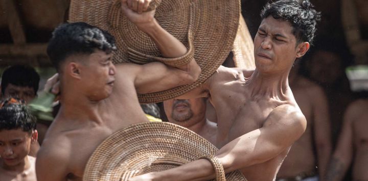 Los aldeanos participan en el ritual anual "Perang Pandan" (lucha de hojas de Pandanus), conocido localmente como "Mekare-kare", que honra a Indra, el dios hindú de la guerra, en Tenganan Pegringsingan, en la isla turística de Bali, Indonesia.