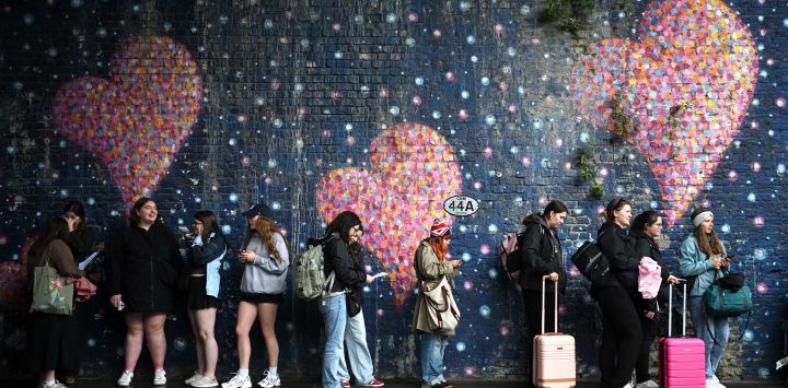 Los fans del cantante británico Harry Styles hacen cola para entrar en una tienda efímera que vende merchandising antes de la etapa británica de su gira Harry Styles: Together, Together, en el este de Londres, víspera del concierto inaugural.