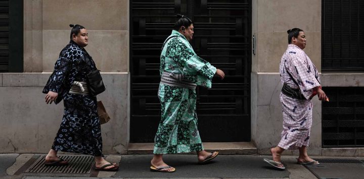 Luchadores de sumo caminan por una calle de París. París acoge el Torneo de Sumo de junio de 2026.