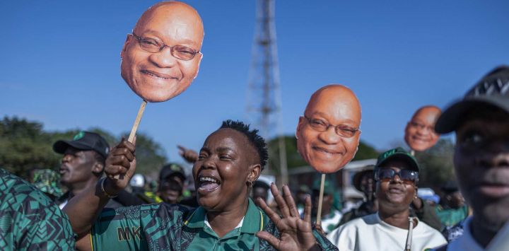 Simpatizantes del partido uMkhonto we Sizwe (MK) sostienen máscaras con la imagen del expresidente sudafricano y líder del partido, Jacob Zuma, durante una marcha de protesta en Durban, Sudáfrica.