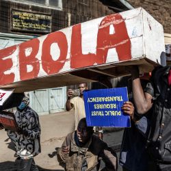 Manifestantes portan un ataúd simbólico durante una marcha contra un controvertido centro de cuarentena para el ébola, construido por Estados Unidos en la base aérea de Laikipia, en Nanyuki. Varios kenianos fueron arrestados ese mismo día en las últimas protestas contra la construcción de un centro de cuarentena para ciudadanos estadounidenses en una ciudad turística. El centro, ubicado en la base aérea de Laikipia, en Nanyuki, a la sombra del monte Kenia, albergará a los estadounidenses procedentes de la República Democrática del Congo (RDC), país que sufre un importante brote de ébola. | Foto:LUIS TATO / AFP