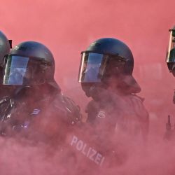 Agentes de policía con equipo antidisturbios, escudos y pistolas de balas de goma operan en medio de una nube de humo rojo proveniente de una bomba de humo durante una manifestación de la coalición "No-G7", integrada por más de 60 asociaciones, sindicatos y grupos de izquierda "contra el fascismo y el imperialismo", un día antes del inicio de la cumbre, en Ginebra. La edición de 2026 de la cumbre del G7 se celebrará en la ciudad francesa de Évian-les-Bains, cerca de Suiza, y contará con la asistencia de líderes de los países, así como del jefe de la diplomacia de la UE y ministros de Brasil, Canadá, Emiratos Árabes Unidos y Turquía. | Foto:FABRICE COFFRINI / AFP