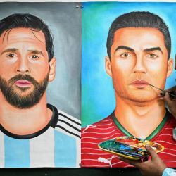 Un artista da los últimos retoques a una pintura que representa a los futbolistas argentinos Lionel Messi y portugués Cristiano Ronaldo en Amritsar, India, durante del Mundial de Fútbol de la FIFA 2026. | Foto:Narinder Nanu / AFP