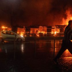 Un residente camina frente a un mercado en llamas tras un ataque con misiles rusos en Kiev, en medio de la invasión rusa de Ucrania. Rusia lanzó una andanada de misiles contra varias ciudades importantes de Ucrania, incendiando la histórica Catedral de la Dormición de Kiev y causando nueve muertos, mientras que los ataques ucranianos cobraron tres vidas al sur de Moscú. | Foto:OLEKSII FILIPPOV / AFP