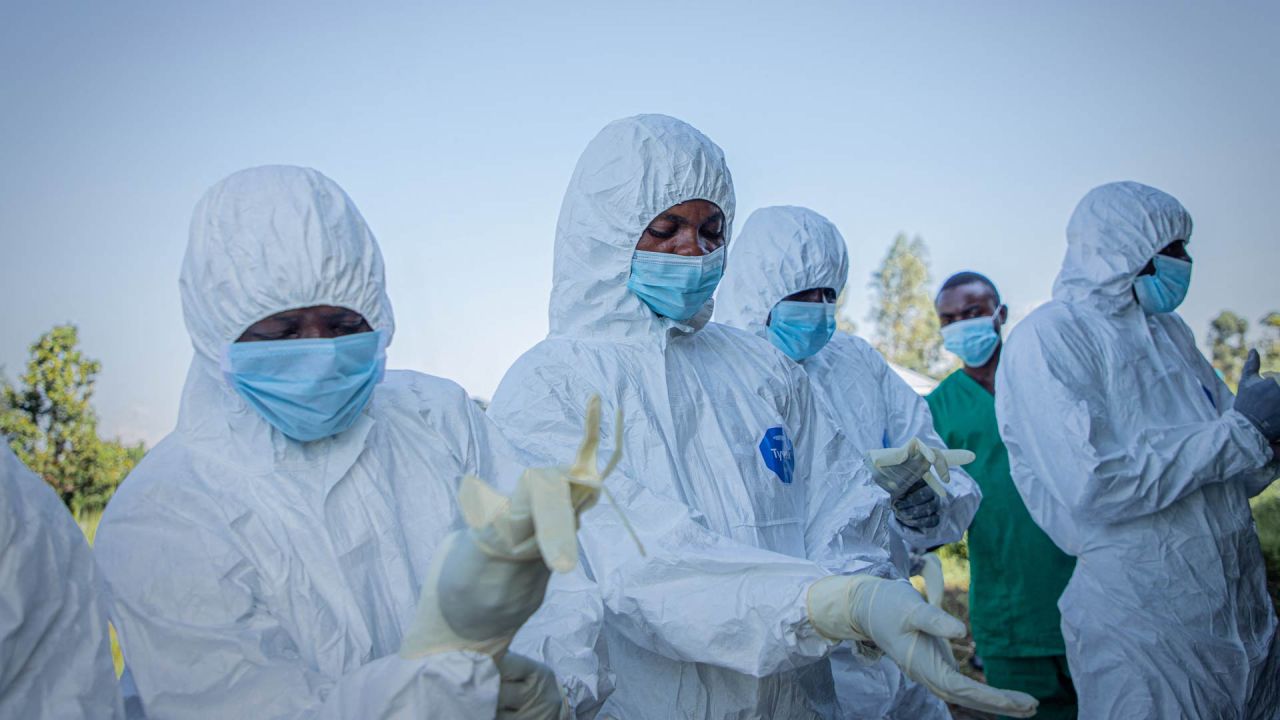 Voluntarios se colocan sus equipos de protección personal antes de recuperar el cuerpo de un niño de 3 años, presuntamente fallecido a causa del virus del Ébola, en Bunia, República Democrática del Congo. | Foto:Benediction Murhabazi / AFP