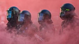 Agentes de policía con equipo antidisturbios, escudos y pistolas de balas de goma operan en medio de una nube de humo rojo proveniente de una bomba de humo durante una manifestación de la coalición "No-G7", integrada por más de 60 asociaciones, sindicatos y grupos de izquierda "contra el fascismo y el imperialismo", un día antes del inicio de la cumbre, en Ginebra. La edición de 2026 de la cumbre del G7 se celebrará en la ciudad francesa de Évian-les-Bains, cerca de Suiza, y contará con la asistencia de líderes de los países, así como del jefe de la diplomacia de la UE y ministros de Brasil, Canadá, Emiratos Árabes Unidos y Turquía.