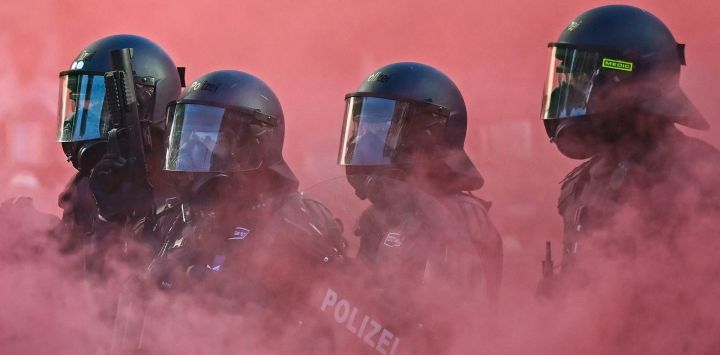 Agentes de policía con equipo antidisturbios, escudos y pistolas de balas de goma operan en medio de una nube de humo rojo proveniente de una bomba de humo durante una manifestación de la coalición "No-G7", integrada por más de 60 asociaciones, sindicatos y grupos de izquierda "contra el fascismo y el imperialismo", un día antes del inicio de la cumbre, en Ginebra. La edición de 2026 de la cumbre del G7 se celebrará en la ciudad francesa de Évian-les-Bains, cerca de Suiza, y contará con la asistencia de líderes de los países, así como del jefe de la diplomacia de la UE y ministros de Brasil, Canadá, Emiratos Árabes Unidos y Turquía.