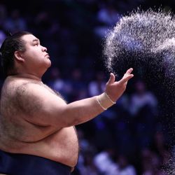 El luchador de sumo japonés Takayasu rocía sal antes de su combate en el primer día del Torneo de Sumo de París 2026, en París, Francia. | Foto:Behrouz Mehri / AFP