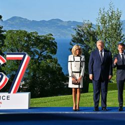 El presidente francés Emmanuel Macron y su esposa Brigitte Macron posan con el presidente estadounidense Donald Trump durante el saludo oficial en el marco de la cumbre del G7, en Évian, al este de Francia. | Foto:Mandel Ngan / AFP