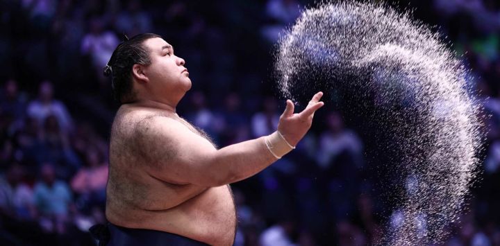 El luchador de sumo japonés Takayasu rocía sal antes de su combate en el primer día del Torneo de Sumo de París 2026, en París, Francia.