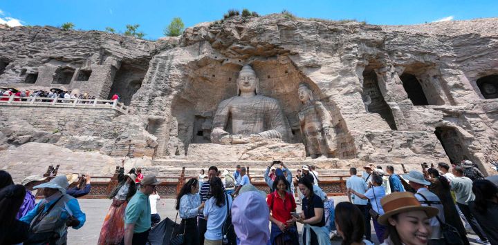 Imagen de turistas visitando las Grutas de Yungang, en Datong, en la provincia de Shanxi, en el norte de China. Datong, hogar de las Grutas de Yungang y considerada una historia viva de la arquitectura china, se ha centrado en los últimos años en aprovechar su rico patrimonio cultural mediante innovaciones de contenido y tecnologías digitales.