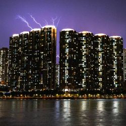 Esta fotografía muestra relámpagos en el cielo detrás de un complejo residencial de gran altura en la isla de Tsing Yi, vistos desde el muelle de Tsuen Wan, en el distrito de Tsuen Wan de los Nuevos Territorios de Hong Kong. | Foto:Philip Fong / AFP
