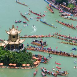 Imagen tomada con un dron de equipos de botes del dragón participando en un desfile acuático, en el distrito de Bijiang de Tongren, en la provincia de Guizhou, en el suroeste de China. | Foto:Xinhua/Peng Jun
