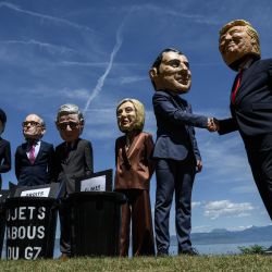 Manifestantes disfrazados con caricaturas de "cabezas gigantes" que representan a los jefes de Estado del G7 (de izquierda a derecha): el primer ministro de Canadá, Mark Carney; la primera ministra de Japón, Sanae Takaichi; el canciller de Alemania, Friedrich Merz; el primer ministro del Reino Unido, Keir Starmer; la primera ministra de Italia, Giorgia Meloni; el presidente de Francia, Emmanuel Macron; y el presidente de Estados Unidos, Donald Trump, posan frente a cubos de basura simulados con carteles de "derechos humanos", "igualdad de género" y "clima" en su interior, durante un evento organizado por la ONG OXFAM en Publier, al este de Francia. | Foto:JEFF PACHOUD / AFP