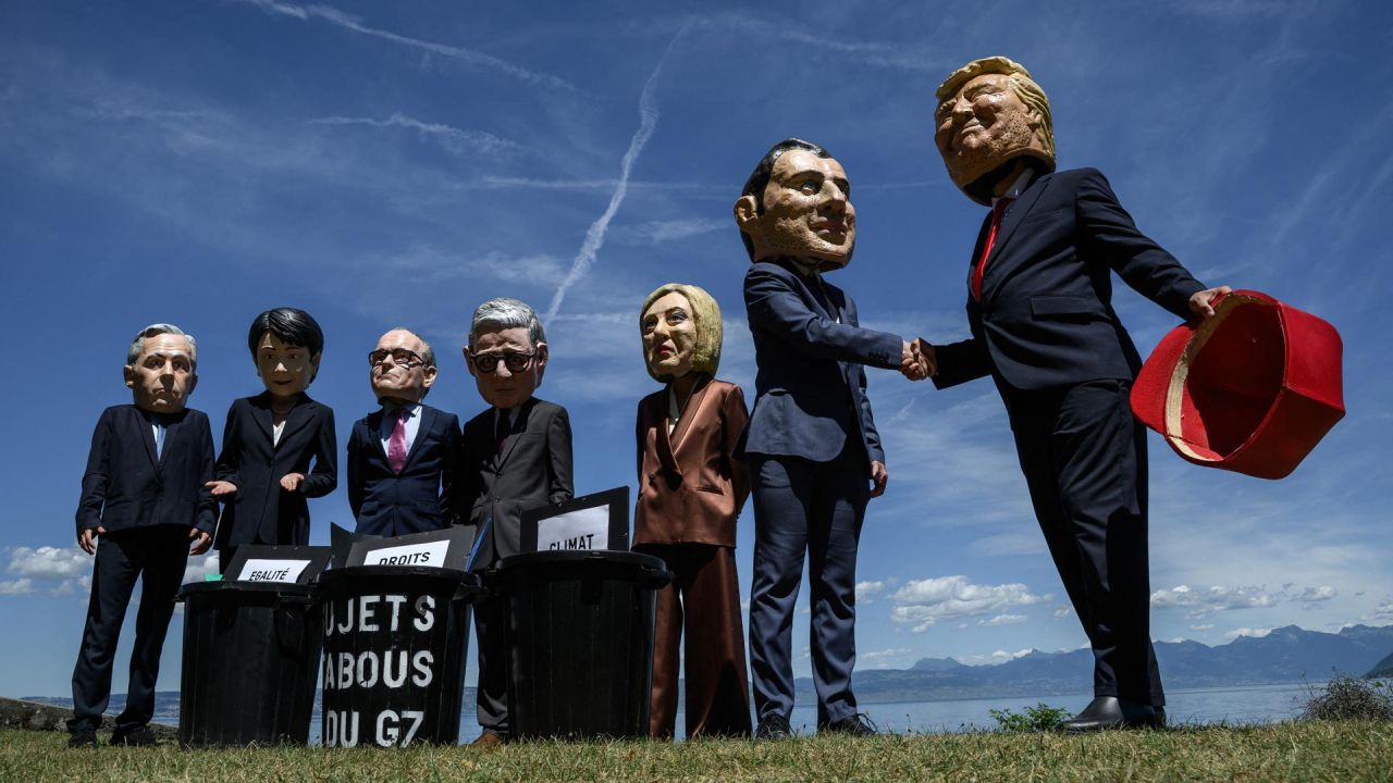 Manifestantes disfrazados con caricaturas de "cabezas gigantes" que representan a los jefes de Estado del G7 (de izquierda a derecha): el primer ministro de Canadá, Mark Carney; la primera ministra de Japón, Sanae Takaichi; el canciller de Alemania, Friedrich Merz; el primer ministro del Reino Unido, Keir Starmer; la primera ministra de Italia, Giorgia Meloni; el presidente de Francia, Emmanuel Macron; y el presidente de Estados Unidos, Donald Trump, posan frente a cubos de basura simulados con carteles de "derechos humanos", "igualdad de género" y "clima" en su interior, durante un evento organizado por la ONG OXFAM en Publier, al este de Francia. | Foto:JEFF PACHOUD / AFP