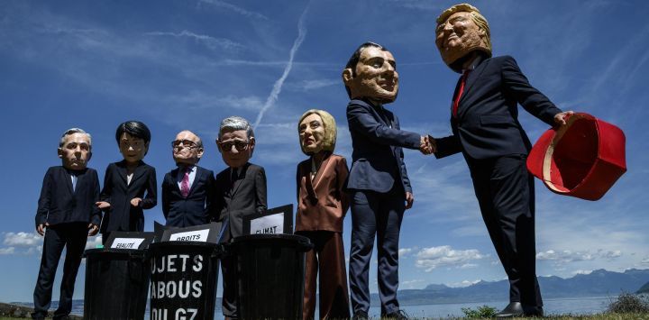 Manifestantes disfrazados con caricaturas de "cabezas gigantes" que representan a los jefes de Estado del G7 (de izquierda a derecha): el primer ministro de Canadá, Mark Carney; la primera ministra de Japón, Sanae Takaichi; el canciller de Alemania, Friedrich Merz; el primer ministro del Reino Unido, Keir Starmer; la primera ministra de Italia, Giorgia Meloni; el presidente de Francia, Emmanuel Macron; y el presidente de Estados Unidos, Donald Trump, posan frente a cubos de basura simulados con carteles de "derechos humanos", "igualdad de género" y "clima" en su interior, durante un evento organizado por la ONG OXFAM en Publier, al este de Francia.
