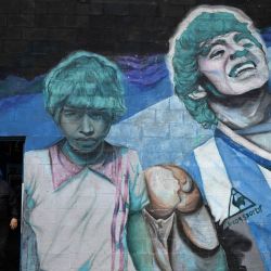 Pancho Torres, de 65 años, amigo de la infancia del fallecido legendario futbolista argentino Diego Maradona, se encuentra en la entrada del campo "El Potrero de D10S" en Villa Fiorito, en las afueras de Buenos Aires, donde Maradona dio sus primeros pasos jugando al fútbol en el club de su infancia, Estrella Roja, cerca de su casa natal. | Foto:LUIS ROBAYO / AFP