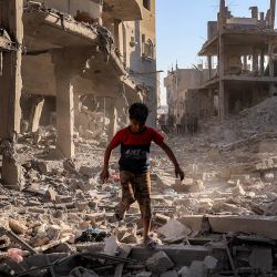Un niño camina entre los escombros de un edificio destruido tras un bombardeo israelí después de una orden de evacuación, en el campamento de refugiados palestinos de Maghazi, en el centro de la Franja de Gaza. Gaza sigue sumida en la violencia diaria a pesar del alto el fuego formal vigente desde octubre de 2025, y tanto el ejército israelí como Hamás se acusan mutuamente de violar la tregua. | Foto:Eyad Baba / AFP